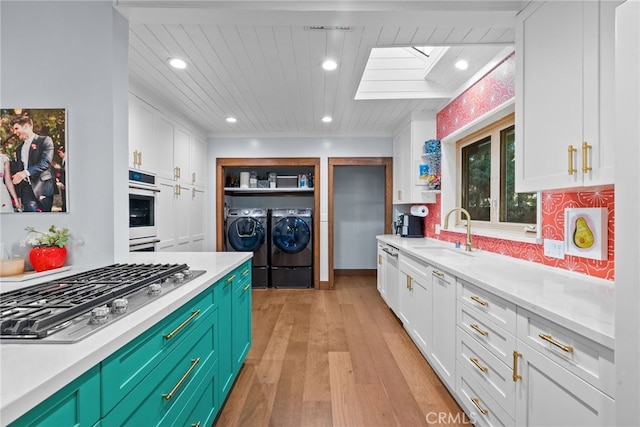 1719 Monte Vista St, Pasadena, CA 91106 - kitchen with a sink, appliances with stainless steel finishes, washing machine and clothes dryer, a skylight, and white cabinets
