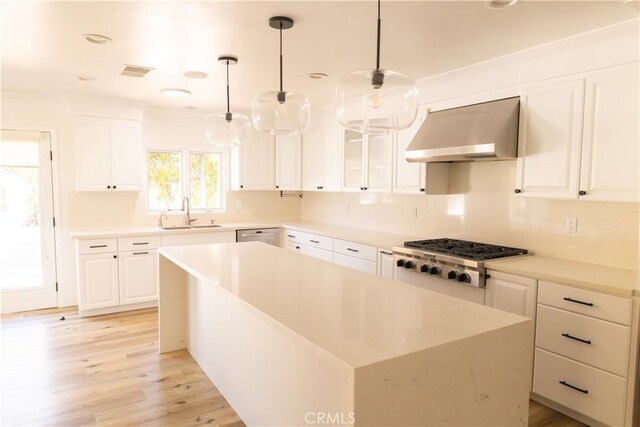 12539 Presnell St, Los Angeles, CA 90066 - kitchen with ventilation hood, stainless steel appliances, a sink, light wood-style flooring, and white cabinets