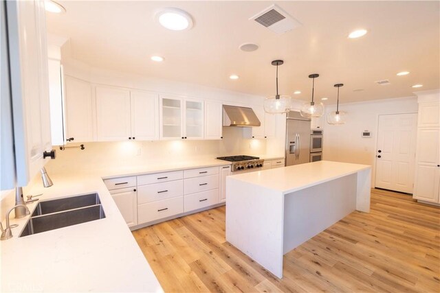 12539 Presnell St, Los Angeles, CA 90066 - kitchen featuring appliances with stainless steel finishes, range hood, light wood-style flooring, a sink, and a center island