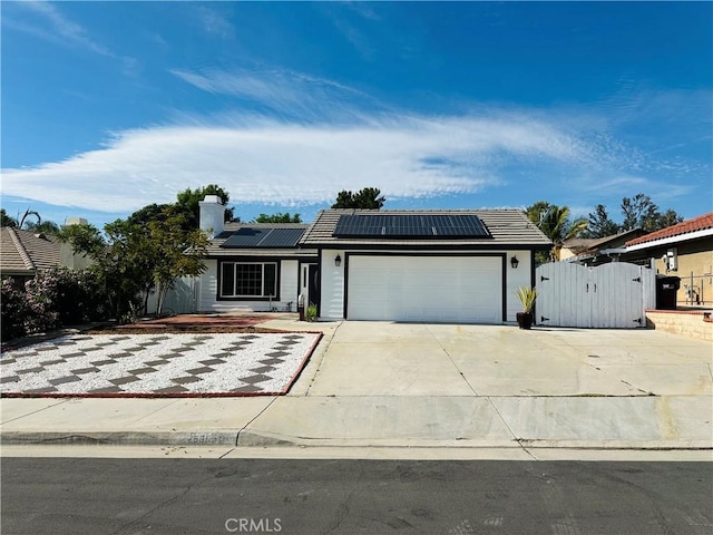 25690 Onate Dr, Moreno Valley, CA 92557 - ranch-style home with a gate, a garage, driveway, roof mounted solar panels, and a tile roof