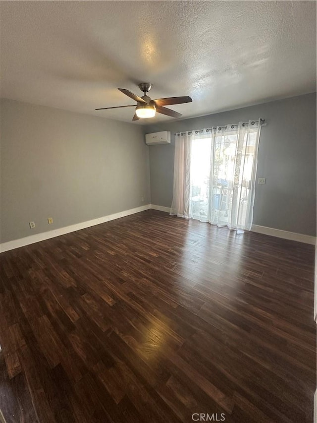 25690 Onate Dr, Moreno Valley, CA 92557 - empty room with an AC wall unit, a ceiling fan, dark wood-style flooring, a textured ceiling, and baseboards
