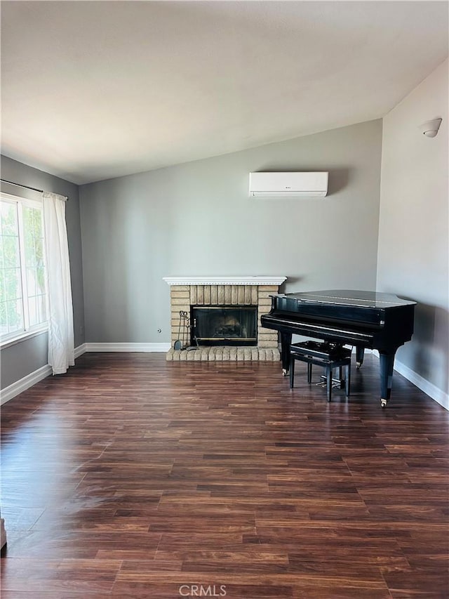 25690 Onate Dr, Moreno Valley, CA 92557 - living area with a wall unit AC, baseboards, dark wood-style flooring, and a brick fireplace