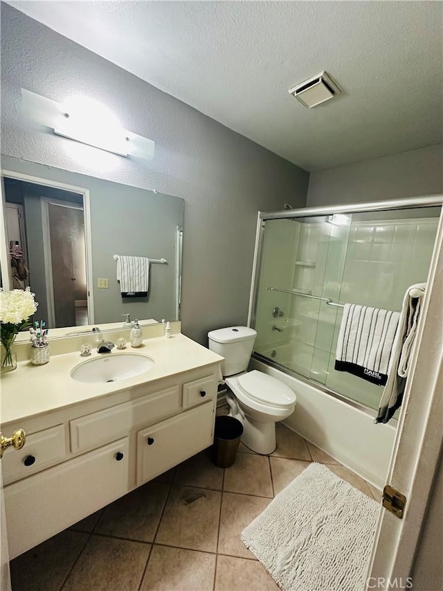25690 Onate Dr, Moreno Valley, CA 92557 - bathroom featuring tile patterned flooring, vanity, toilet, enclosed tub / shower combo, and a textured ceiling