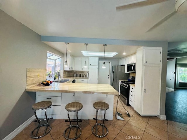 25690 Onate Dr, Moreno Valley, CA 92557 - kitchen featuring appliances with stainless steel finishes, a sink, a peninsula, backsplash, and light countertops