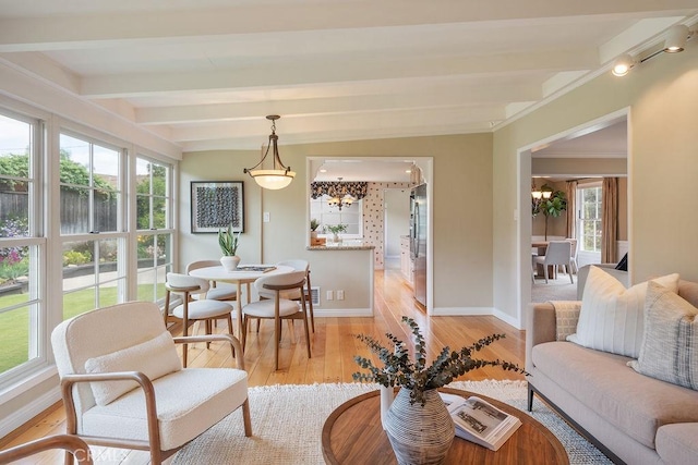 14691 Leon Pl, Tustin, CA 92780 - living area featuring a chandelier, light wood-style flooring, beam ceiling, baseboards, and ornamental molding