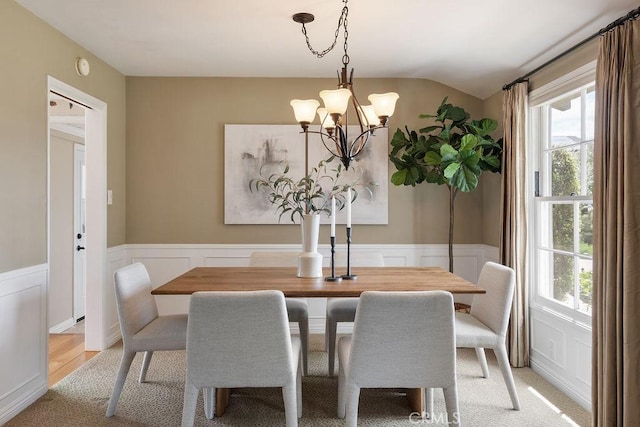 14691 Leon Pl, Tustin, CA 92780 - dining space featuring a decorative wall, a chandelier, wainscoting, lofted ceiling, and light wood-type flooring