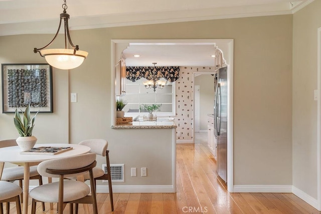 14691 Leon Pl, Tustin, CA 92780 - dining area with baseboards, light wood finished floors, crown molding, and a chandelier