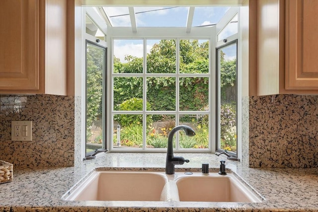 14691 Leon Pl, Tustin, CA 92780 - kitchen view of a sink, backsplash, light stone counters, and light brown cabinetry
