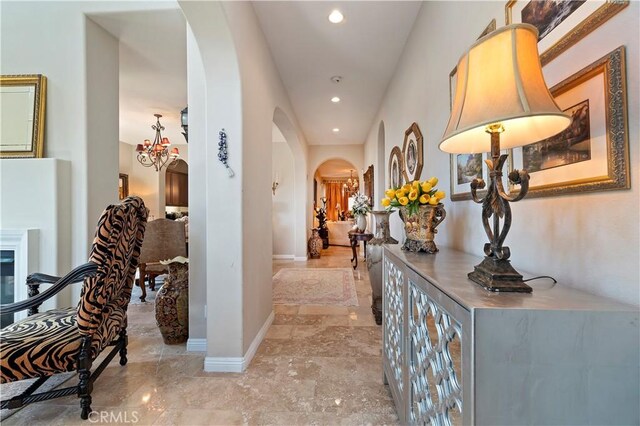 16418 Village Meadow Dr, Riverside, CA 92503 - hallway featuring arched walkways, recessed lighting, a chandelier, baseboards, and light marble finish floors