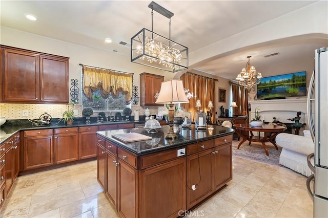 16418 Village Meadow Dr, Riverside, CA 92503 - kitchen with a chandelier, arched walkways, freestanding refrigerator, decorative backsplash, and recessed lighting