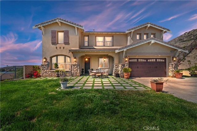 16418 Village Meadow Dr, Riverside, CA 92503 - back of property at dusk featuring stucco siding, concrete driveway, and stone siding
