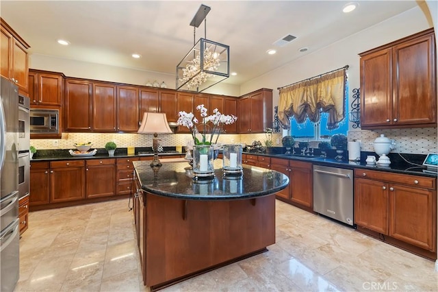 16418 Village Meadow Dr, Riverside, CA 92503 - kitchen featuring appliances with stainless steel finishes, tasteful backsplash, a kitchen island, dark stone countertops, and recessed lighting