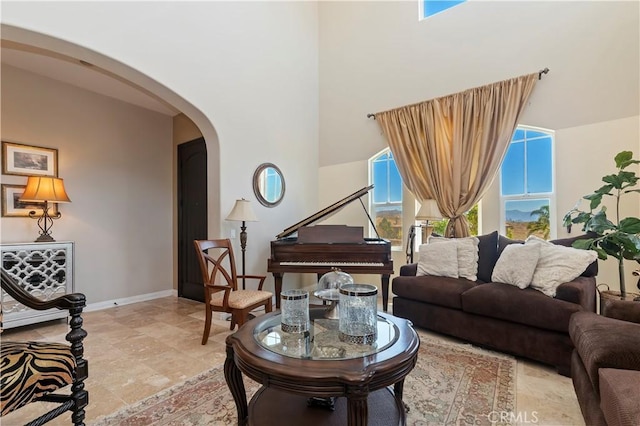16418 Village Meadow Dr, Riverside, CA 92503 - living room with arched walkways, a towering ceiling, and baseboards