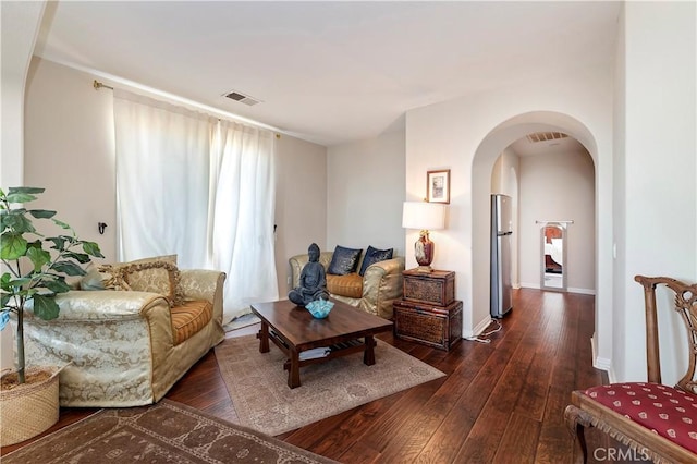 16418 Village Meadow Dr, Riverside, CA 92503 - living area featuring dark wood finished floors, arched walkways, and baseboards