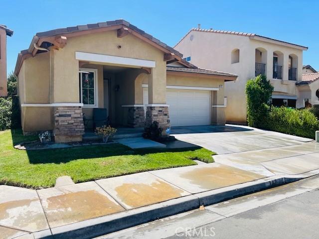 1421 Alta Palma Rd, Perris, CA 92571 - mediterranean / spanish-style house featuring driveway, stucco siding, a garage, a front lawn, and stone siding