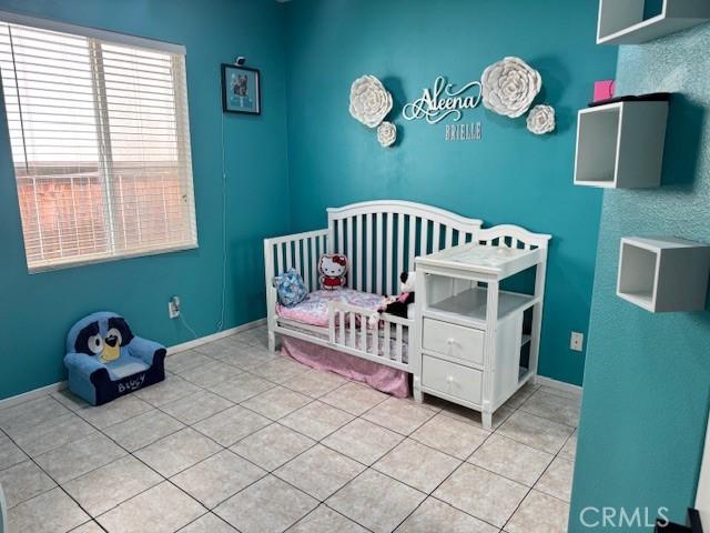 1421 Alta Palma Rd, Perris, CA 92571 - tiled bedroom with a crib and baseboards