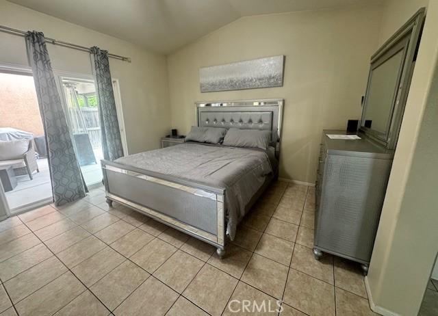 1421 Alta Palma Rd, Perris, CA 92571 - bedroom with lofted ceiling, light tile patterned flooring, access to exterior, and baseboards