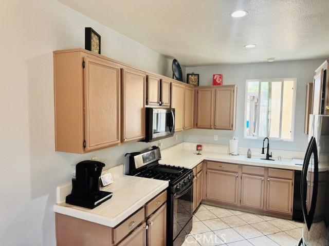 1421 Alta Palma Rd, Perris, CA 92571 - kitchen featuring black appliances, a sink, light countertops, light brown cabinetry, and recessed lighting