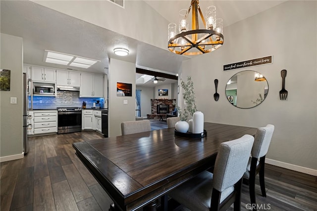 3171 Eagle Lake Ct, Chico, CA 95973 - dining space featuring a chandelier, baseboards, a ceiling fan, dark wood finished floors, and a high ceiling