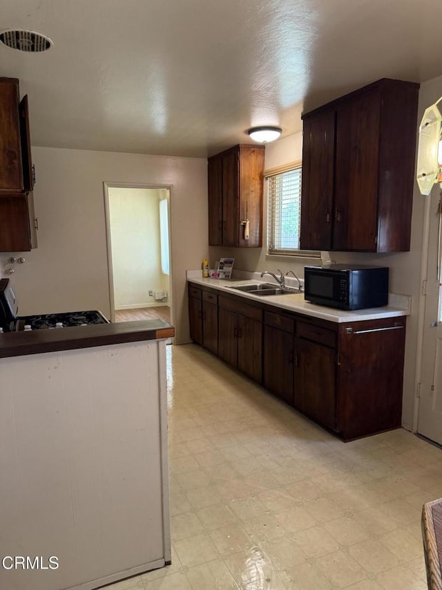 4117 S C St, Oxnard, CA 93033 - kitchen featuring black microwave, light floors, dark brown cabinets, and light countertops