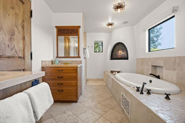 10971 Alto Ct, Oak View, CA 93022 - full bathroom featuring vanity, a bath, stone tile flooring, a fireplace, and baseboards