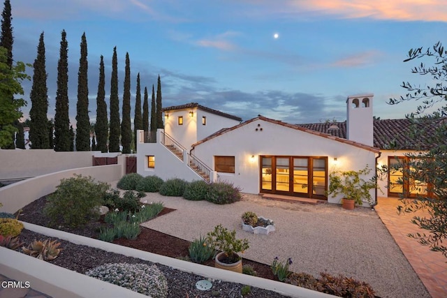 10971 Alto Ct, Oak View, CA 93022 - back of property at dusk with stucco siding, fence, stairs, a tiled roof, and a chimney