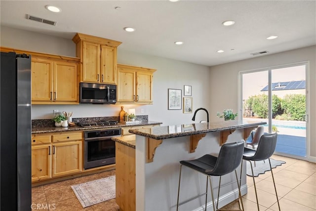 7 Abbott Cir, Chico, CA 95973 - kitchen with appliances with stainless steel finishes, a kitchen bar, dark stone countertops, light brown cabinets, and recessed lighting