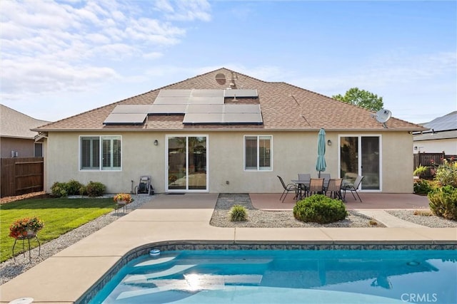 7 Abbott Cir, Chico, CA 95973 - back of house featuring stucco siding, an outdoor pool, solar panels, a patio, and roof with shingles