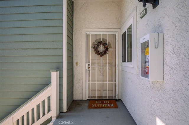 property entrance with stucco siding