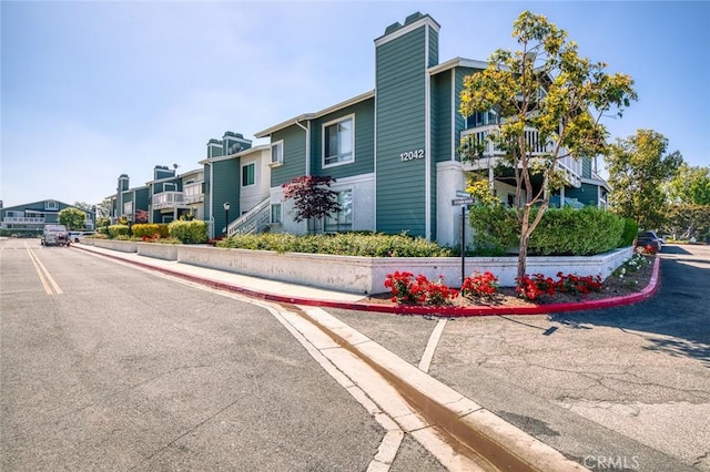 view of asphalt street with curbs, sidewalks, and a residential view