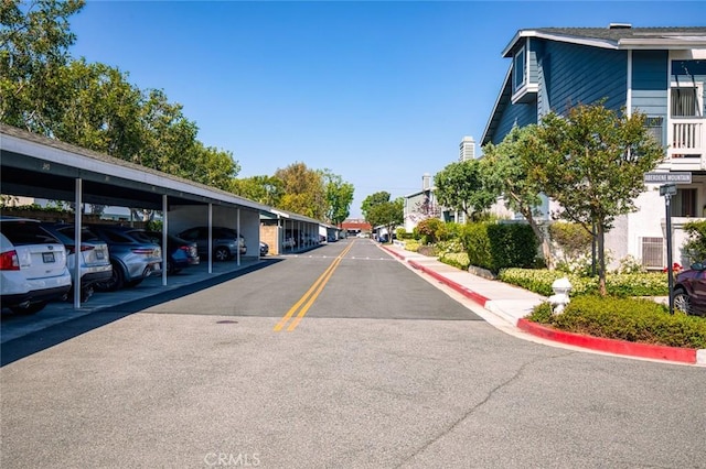 view of asphalt road with curbs