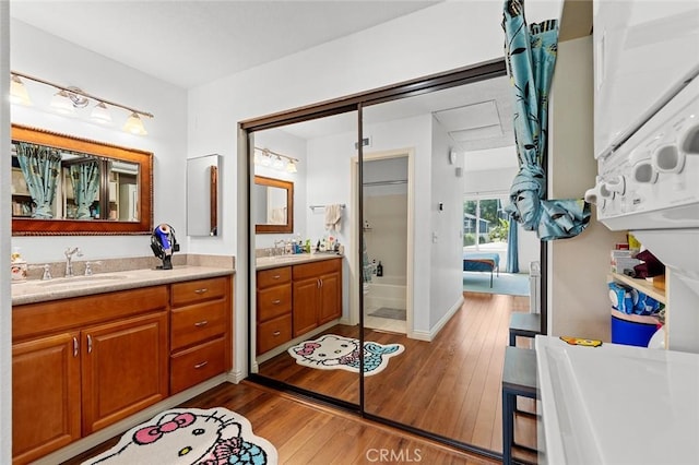 full bath with hardwood / wood-style floors and two vanities