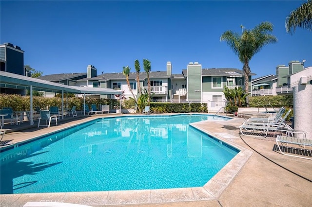 community pool with a residential view and a patio