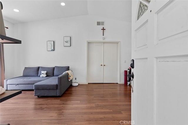 living room featuring wood finished floors, recessed lighting, and vaulted ceiling