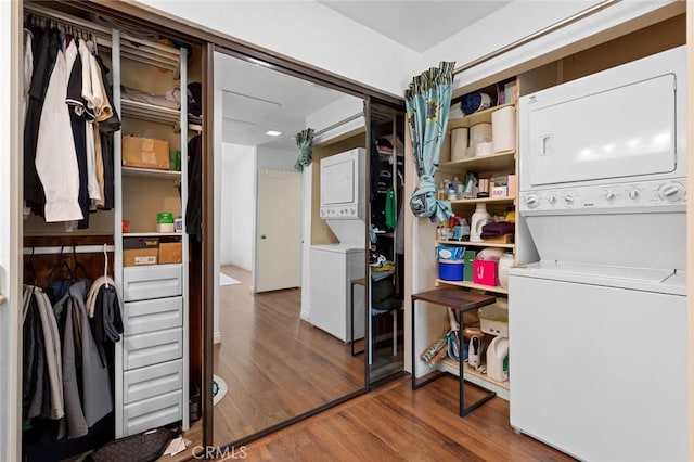 washroom with stacked washer / dryer and wood finished floors