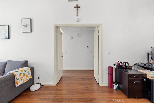 hall featuring light wood-type flooring, baseboards, and attic access