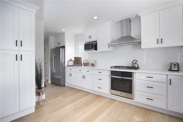 12842 Elizabeth Way, Tustin, CA 92780 - kitchen featuring appliances with stainless steel finishes, wall chimney exhaust hood, light countertops, decorative backsplash, and recessed lighting