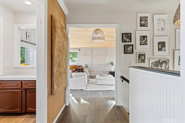3061 Wood Dr, Cambria, CA 93428 - hallway with wood finished floors, baseboards, and a chandelier