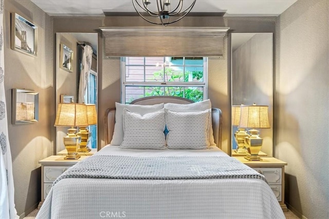 3061 Wood Dr, Cambria, CA 93428 - bedroom featuring a chandelier, baseboards, and a textured wall