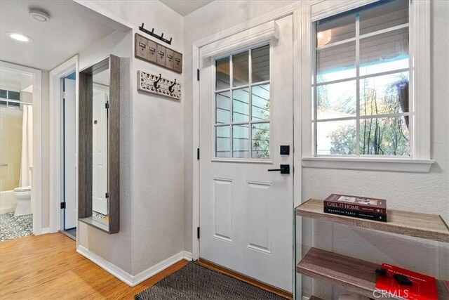 3061 Wood Dr, Cambria, CA 93428 - doorway with light wood-style floors, baseboards, and a textured wall
