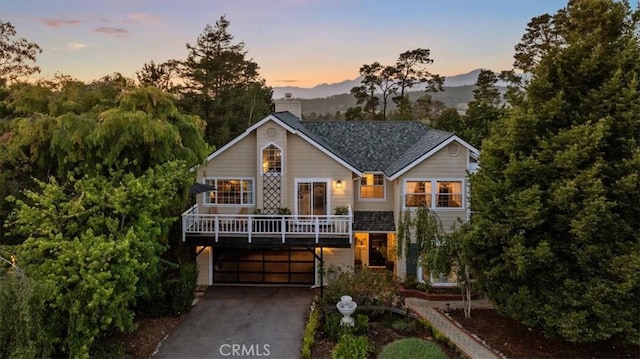 3061 Wood Dr, Cambria, CA 93428 - chalet / cabin with driveway, an attached garage, a mountain view, and a chimney