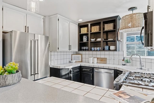 3061 Wood Dr, Cambria, CA 93428 - kitchen with appliances with stainless steel finishes, white cabinets, a sink, and backsplash