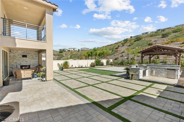 28600 Foothill Way, Saugus, CA 91350 - view of patio featuring an outdoor kitchen, a balcony, a fenced backyard, a gazebo, and an outdoor stone fireplace