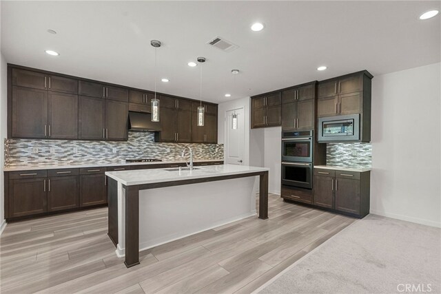 28600 Foothill Way, Saugus, CA 91350 - kitchen featuring stainless steel appliances, ventilation hood, a sink, dark brown cabinetry, and decorative backsplash