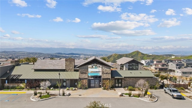 28600 Foothill Way, Saugus, CA 91350 - view of front of home with uncovered parking, a mountain view, stone siding, a standing seam roof, and metal roof
