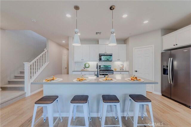 1705 Almond Tree Pl, Upland, CA 91784 - kitchen with appliances with stainless steel finishes, light wood finished floors, a breakfast bar area, and recessed lighting
