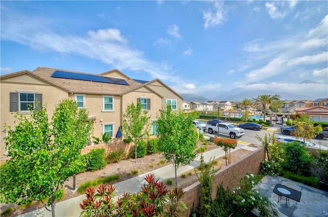 1705 Almond Tree Pl, Upland, CA 91784 - view of property exterior with stucco siding, a residential view, solar panels, and fence