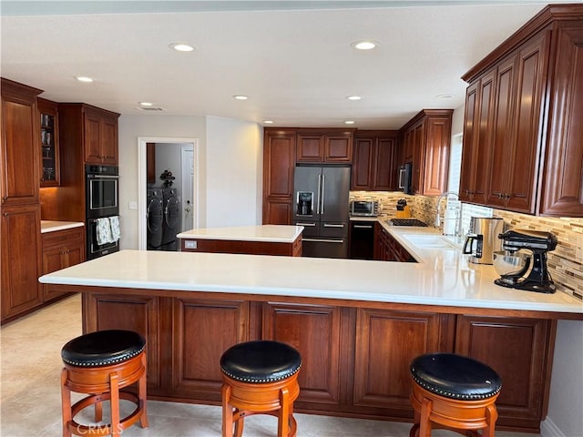 1145 Oakmont Pl, Nipomo, CA 93444 - kitchen with black appliances, separate washer and dryer, light countertops, decorative backsplash, and recessed lighting
