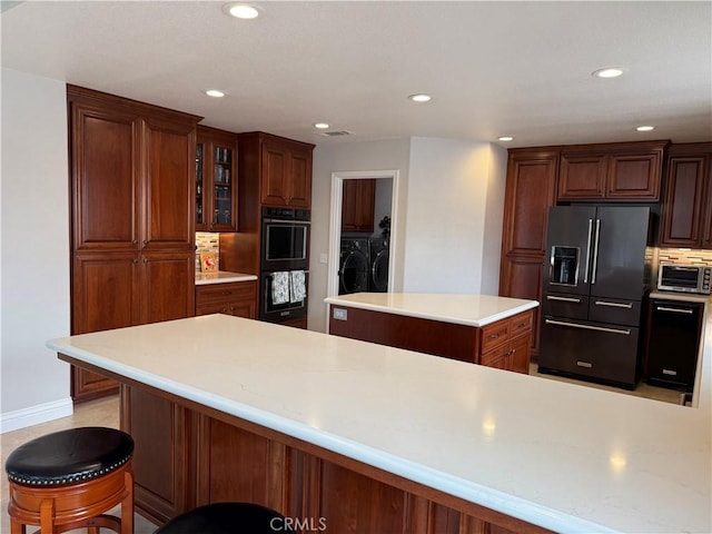 1145 Oakmont Pl, Nipomo, CA 93444 - kitchen with black appliances, washing machine and clothes dryer, a center island, light countertops, and tasteful backsplash