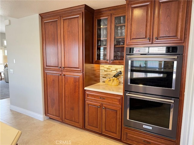 1145 Oakmont Pl, Nipomo, CA 93444 - kitchen with double oven, tasteful backsplash, glass insert cabinets, light countertops, and baseboards